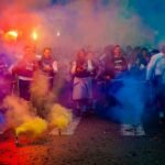 Group of People on Road With Assorted-color Smokes